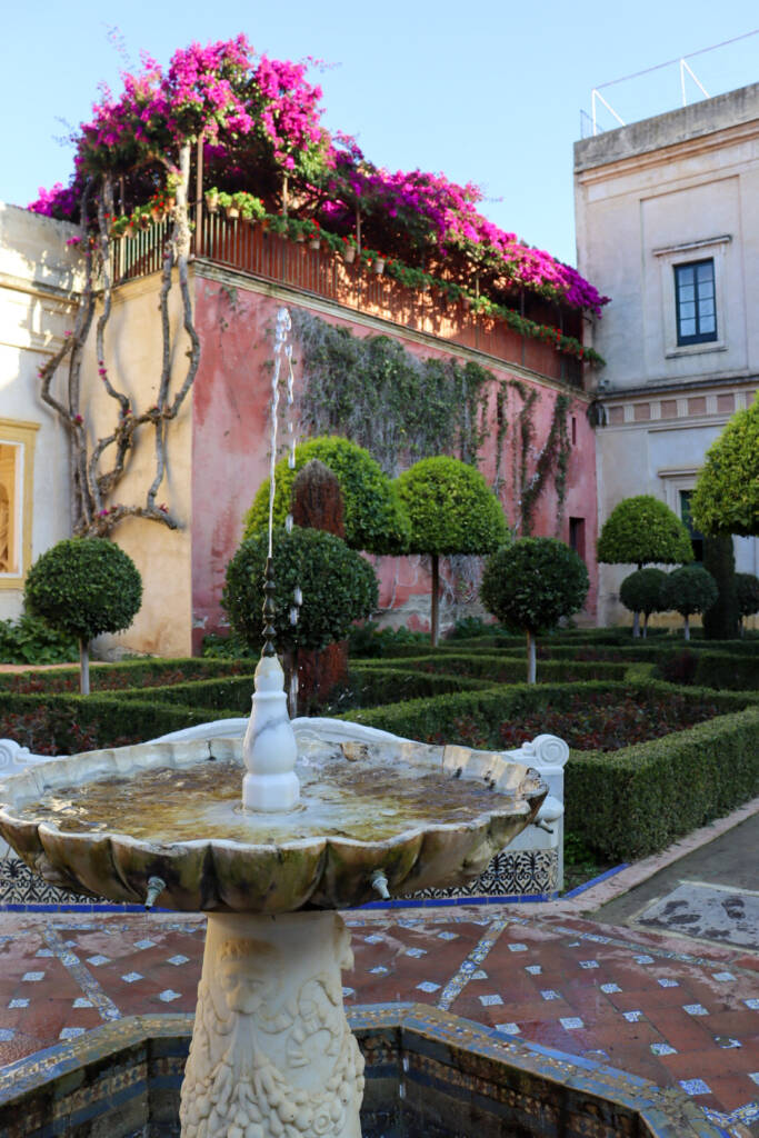 Jardin de la casa de pilatos avec fontaine, arbres, bougainvilliers