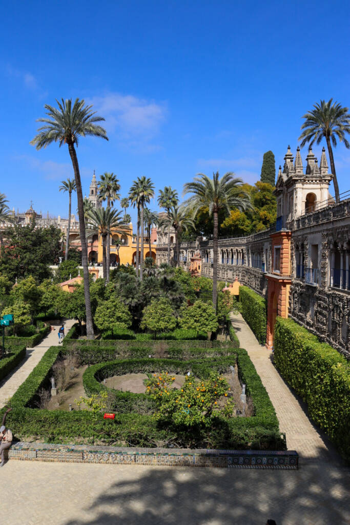 Jardins du Real Alcazar à Séville et vue sur la Giralda et les palmiers