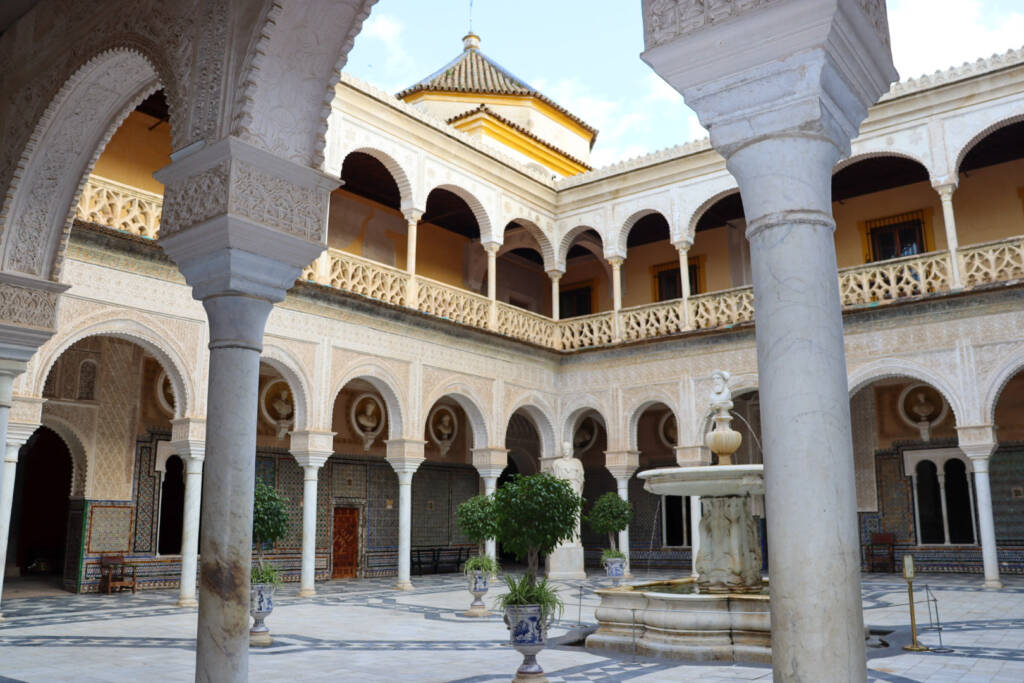 Patio à l'entrée de la Casa De Pilatos à Séville avec sa fontaine et ses balcons