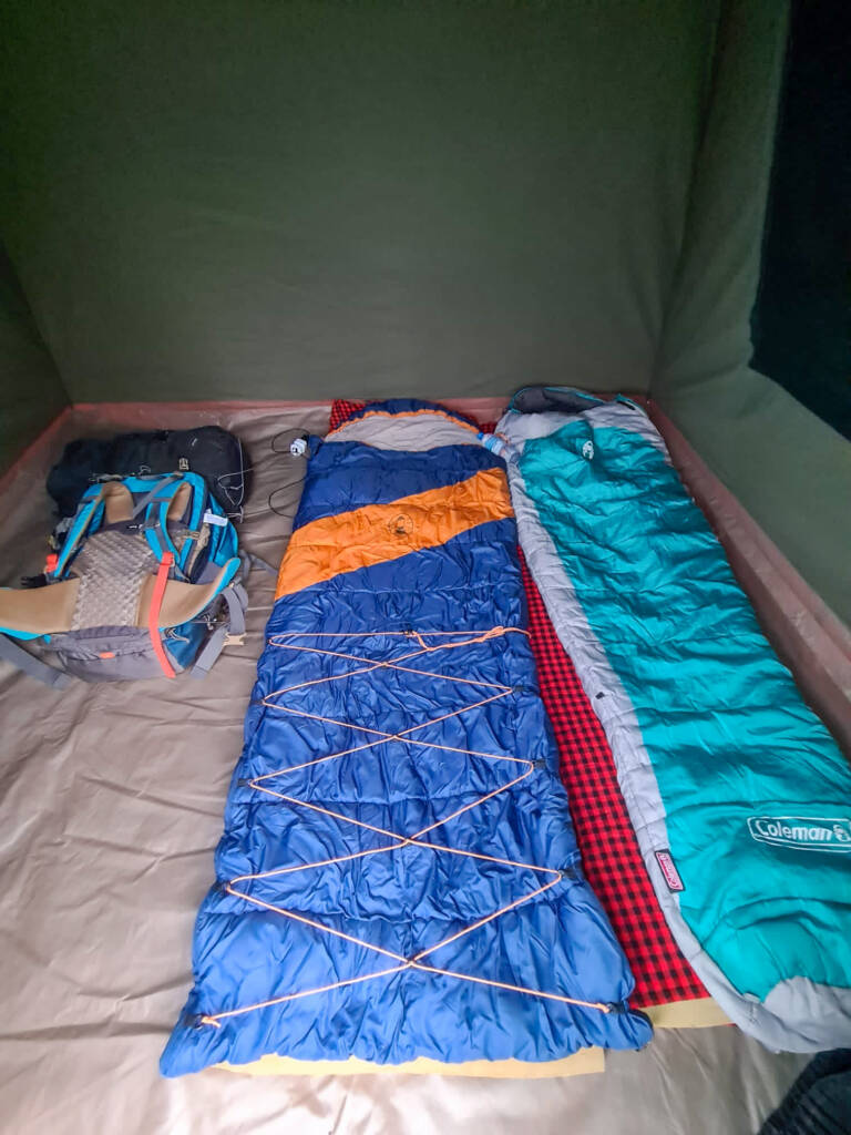 Sac de couchage et sac à dos dans une toile de tente