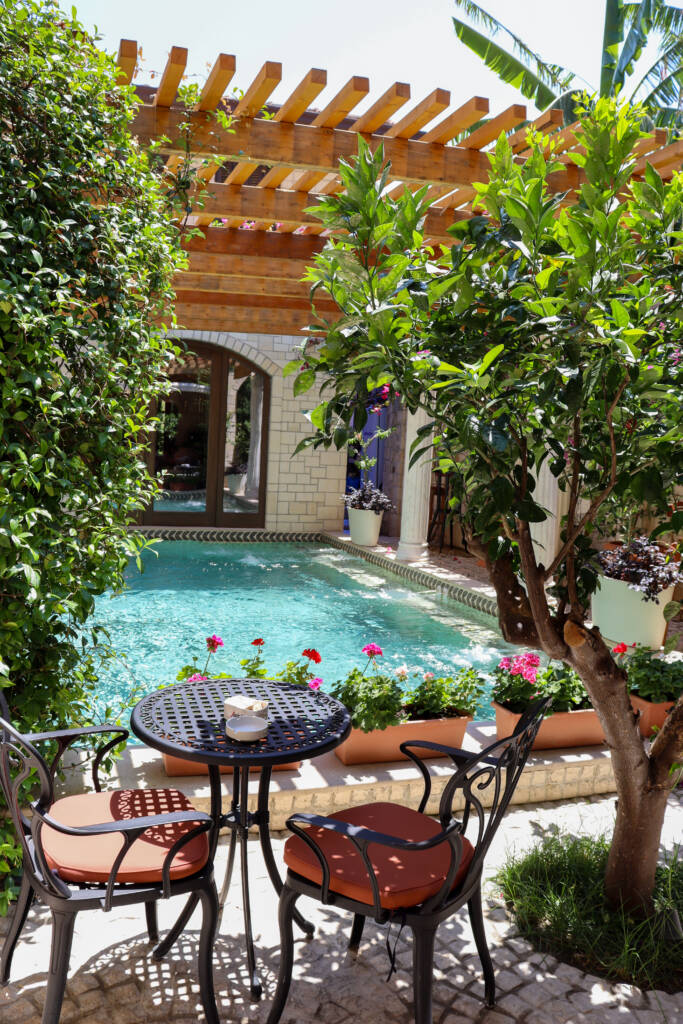 Bassin d'eau, table chaises, arbres et fleurs à l'Antik Bar à Vlorë
