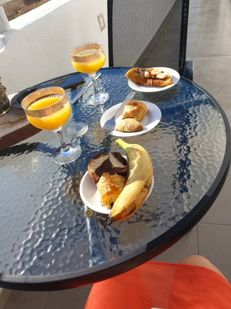 Petit-déjeuner avec jus de fruit, viennoiserie, gâteau et banane