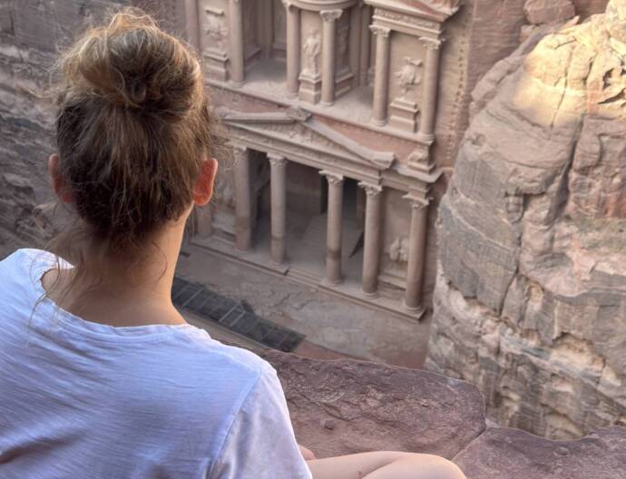 Vue du haut sur le trésor, aussi appelé Khazneh dans la cité de Pétra en Jordanie et moi assise entrain de l'admirer.